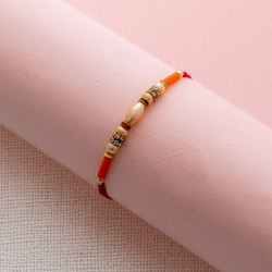 Elegant Pearl Rakhi with American Diamond Embellishment Elegant Pearl Rakhi with American Diamond Embellishment