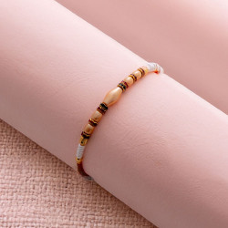 Elegant Pearl Rakhi with Sparkling Diamonds Charms Elegant Pearl Rakhi with Sparkling Diamonds Charms