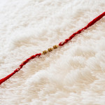 Handcrafted Pearl Rakhi with AD Charms Details Handcrafted Pearl Rakhi with AD Charms Details