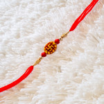 Swastika Rakhi with Red and Golden Beads Swastika Rakhi with Red and Golden Beads